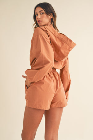 In a Snap Button Hooded Romper in Tan